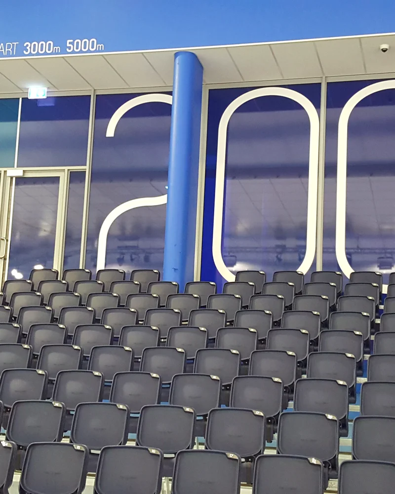 Empty grandstand seating at Thialf ice arena in Heerenveen with 3000m and 5000m start signage
